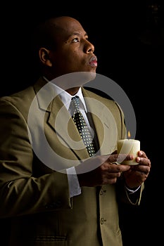 Man Holding Candle in Dark Room