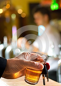 Man holding car key and glass