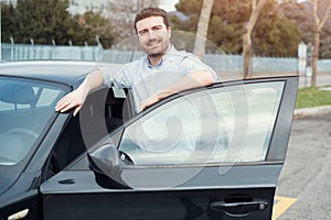 Man holding a car key next to his vehicle