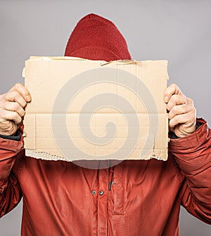 Man holding cardboard sign in winter coat freezing in the cold