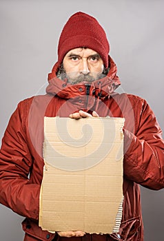 Man holding cardboard sign in winter coat freezing in the cold