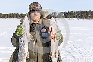 Man holding catch winter fishing pike fish