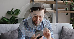 Man holding cellphone feels happy by news in received sms