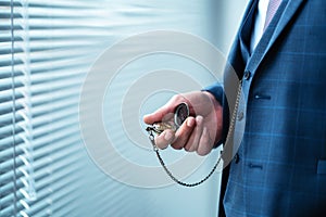 Man is holding and checking his classic pocket watch. Vintage, classic concept .