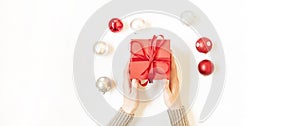 Man holding Christmas present laid on a white table background