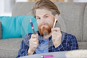 man holding cigarette and electronic vaping machine