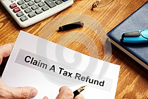 Man is holding Claim a tax refund documents