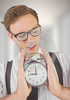 man holding clock in front of blurred bright background