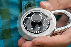 Man holding a code padlock in hand, coded lock object macro, extreme closeup detail. Encryption and decryption