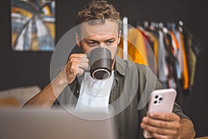 Man Holding Coffee Mug Checking Cell Phone