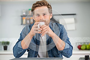 man holding coffee mug in living room