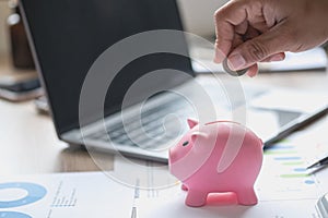 man holding a coin to drop a piggy bank For saving money for the future of the family, saving ideas