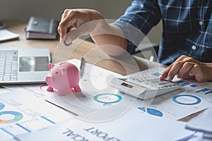 man holding a coin to drop a piggy bank For saving money for the future of the family, saving ideas