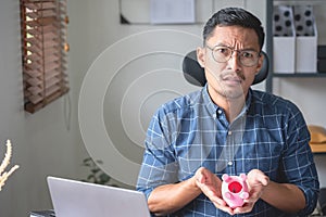 man holding a coin to drop a piggy bank For saving money for the future of the family, saving ideas