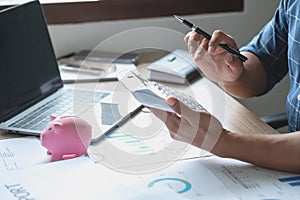 man holding a coin to drop a piggy bank For saving money for the future of the family, saving ideas