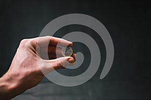 Man holding a coins. Euro currency on a black background. HandÂ´s of young man holding a money. Finance and banking concept.