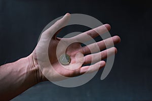 Man holding a coins. Euro currency on a black background. HandÂ´s of young man holding a money. Finance and banking concept.