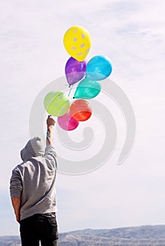 Man holding colorful balloons