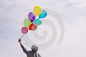 Man holding colorful balloons