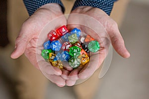 Man Holding Colorful Polyhedral Dice Playing Dungeons and Dragons photo