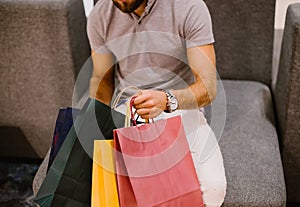 A man is holding colorful shopping bags