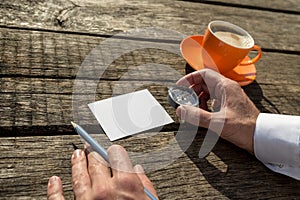 Man holding compass and pencil ready to write on blank paper