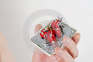 Man holding a computer outlet against a white background. Intern