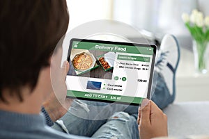 Man holding computer tablet with app delivery food on screen