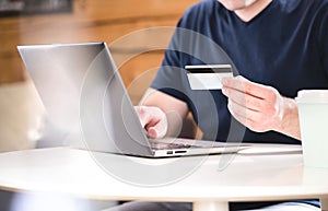 Man holding credit card and typing bank information.