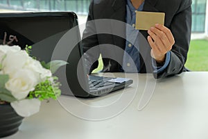 man holding credit card using computer for online shopping. businessman purchasing on internet, make payment on website