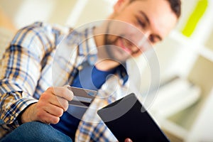 Man holding credit card and using digital tablet for online shopping