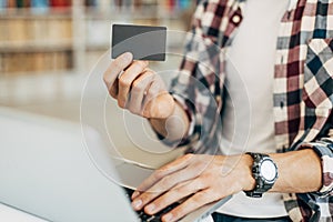 Man holding credit card and using laptop, concept of online shopping, online payment