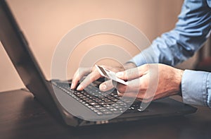 Man holding credit card and using laptop. Online payment and shopping.