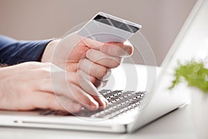Man holding credit card and using laptop. Online shopping concept