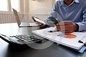 Man holding credit card using smart phone for online shopping. businessman make payment on internet