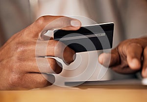 .. Man holding credit card and using tablet. Closeup of mans hands holding bank card while doing online shopping or