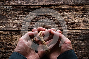 Man holding a cross on table