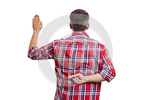 Man holding crossed fingers behind back as fake oath