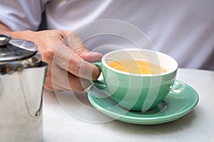 Man holding a cup of chamomile tea