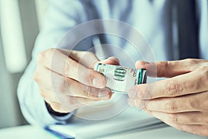 Man holding cutlet of us dollar banknotes in hands. Money credit concept. Toned picture.