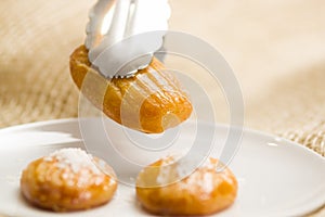 Man is holding a delicious turkish dessert sekerpare with coconut powder with a bakery clamp