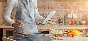 Man holding digital tablet and cooking at kitchen