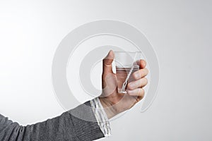 Man holding a disposable plastic cup with water. The lack of drinking water. Water for proper nutrition