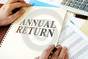 Man holding document with Annual return. photo