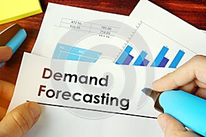 Man holding documents with Demand Forecasting. photo