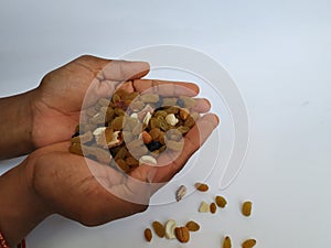 Man Holding and dropping from distance of Mixed Dry fruits isolated on white background