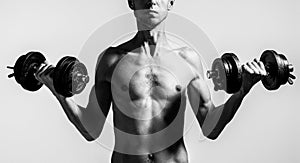 Man holding dumbbell in hand. Skinny guy hold dumbbells up in hands. A thin man in sports with dumbbells.Black and white