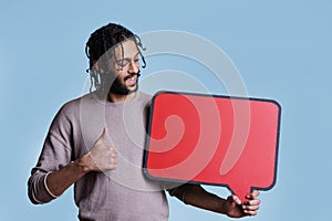 man holding empty red speech bubble, showing thumb up