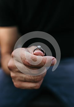 Man holding an engagement ring in his hand