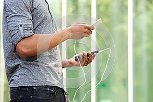 Man holding external battery and smart phone